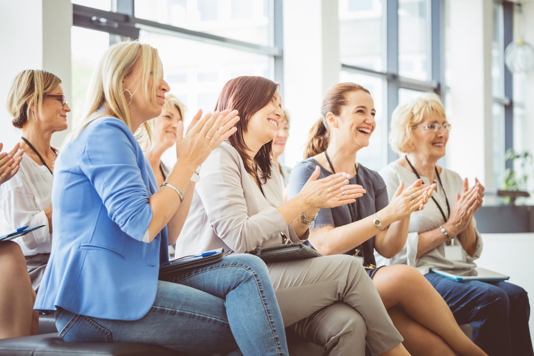 Group of women clapping at seminar